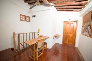 a dining room with a table and a wooden door at Casa Serrano - Callejón de Don Blas in Mompós