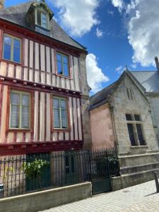 una casa vieja y un edificio con una valla en Le KEMPER - Cœur de ville, en Quimper