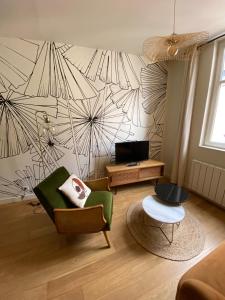 a living room with a couch and a chair at Le KEMPER - Cœur de ville in Quimper