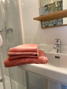 a pile of towels sitting on top of a bathroom sink at Le KEMPER - Cœur de ville in Quimper