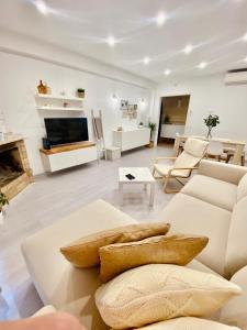 sala de estar con muebles blancos y chimenea en Vivenda Sossego do Mar, en Ferragudo