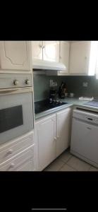 a kitchen with white cabinets and a stove top oven at Home2Home Guesthouse in Christ Church