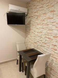 comedor con mesa, sillas y pared en Apart Hotel Ayres De Termas en Termas de Río Hondo
