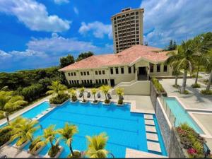 a house with a swimming pool and palm trees at Splendido Tower 2 Ann's Unit NETFLIX, FreeParking in Tagaytay