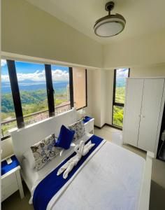 um quarto com uma cama grande e uma janela grande em Splendido Tower 2 Ann's Unit em Tagaytay