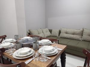 a table with plates and glasses and a couch at Sweet Home in Historical Area 3B in Istanbul