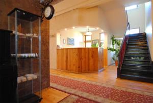 a room with a staircase and a clock on the wall at Parko Vila in Druskininkai