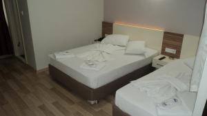 two beds in a hotel room with white sheets at Kadikoy Bade 3 Hotel in Istanbul