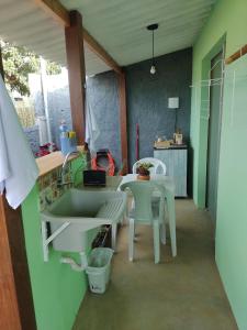 een keuken met een wastafel en een tafel en stoelen bij Flores do Cerrado in Alto Paraíso de Goiás