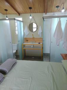 a bathroom with a bed and a sink and a mirror at Flores do Cerrado in Alto Paraíso de Goiás