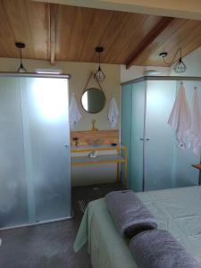 a bedroom with a bed and a bathroom with a sink at Flores do Cerrado in Alto Paraíso de Goiás