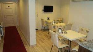 una camera con tavolo e sedie bianchi e una camera con TV di Kadikoy Bade 3 Hotel a Istanbul