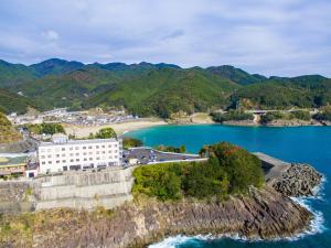 Un'isola in acqua con un edificio bianco sopra di Hotel Nami a Kumano