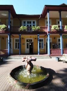 a fountain in a courtyard in front of a building at Parko Vila in Druskininkai