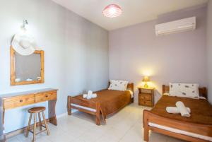 een slaapkamer met 2 bedden, een bureau en een spiegel bij Pine tree Apartment & sunset in Ágios Nikólaos