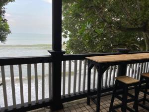 - stół i krzesła na balkonie z widokiem na plażę w obiekcie Lippo carita selatan condo 3bedroom langsung pantai w mieście Carita