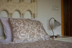 a bed with a pillow and a lamp on a table at Domus Nostra in Furnas