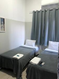 Dos camas en una habitación de hospital con toallas. en Ágape Hotel, en Rio Verde