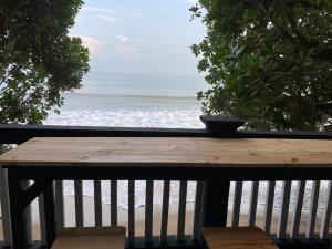 a wooden table on a balcony with a view of the ocean at Villa Lippo carita langsung pantai 3bedroom in Pandegelang