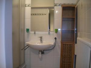 ein Badezimmer mit Waschbecken und Spiegel in der Unterkunft Apartment Sandeman in De Panne + 11 Fotos