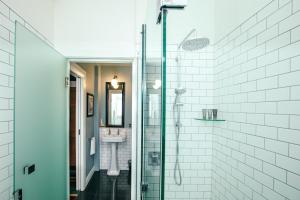 a bathroom with a glass shower with a sink at Art Deco Masonic Hotel in Napier