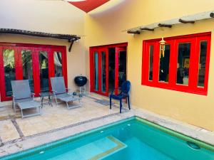 a house with a swimming pool and red windows at Casa Boho 1 in Sayulita