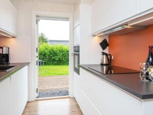 a kitchen with an open door leading to a yard at 8 person holiday home in Hemmet in Falen