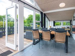 a screened in porch with a table and chairs at 8 person holiday home in Hemmet in Falen
