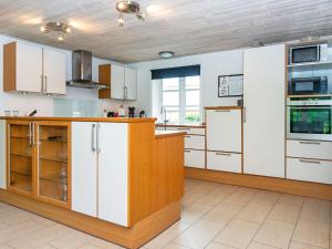 a kitchen with white cabinets and a wooden counter top at Holiday home Silkeborg XVII in Silkeborg