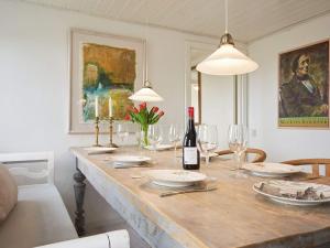 ein Esszimmer mit einem Tisch und Weingläsern in der Unterkunft Holiday home Aakirkeby IX in Åkirkeby