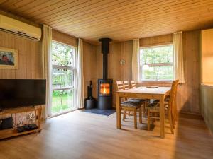 凡島的住宿－Holiday home Fanø CIII，一间带桌子和壁炉的用餐室
