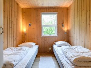 two beds in a room with a window at Tranquil Oasis in Rindby in Fanø