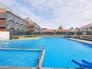 a large blue swimming pool with a slide at 4 person holiday home on a holiday park in Faaborg in Fåborg