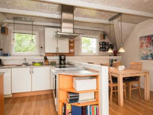 a kitchen with a table and a dining room at 4 person holiday home in Ringk bing in Søndervig