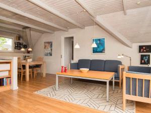 a living room with a table and a couch at 4 person holiday home in Ringk bing in Søndervig