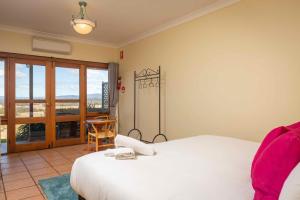 una camera da letto con un letto bianco e un balcone di Sovereign Hill Country Estate a Lovedale Altre 17 foto