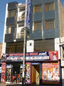 a building with many signs in front of it at HOSTAL JUMI in Tacna