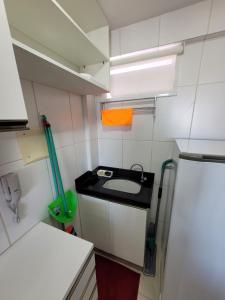 een kleine keuken met een wastafel en een oranje handdoek bij Flat Luxo Completo em Boa Viagem junto ao Shopping in Recife