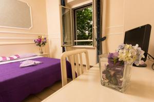 une chambre avec une table et un vase de fleurs dans l'établissement Allegria Fitzroy Cesr, à Rome
