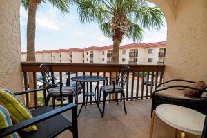 a balcony with chairs and tables and a building at Unit 6202 - Ocean & Racquet Resort in Saint Augustine Beach