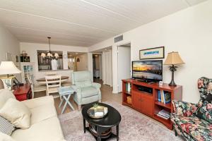 a living room with a couch and a tv at Unit 6202 - Ocean & Racquet Resort in Saint Augustine Beach