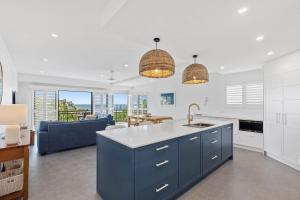 陽光海灘的住宿－6 Seabreeze Spacious Newly Renovated Apartment with Ocean Views，厨房以及带蓝色和白色厨房的客厅。