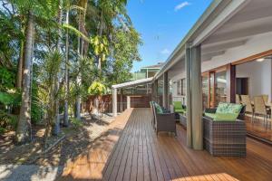an open deck with chairs and trees on a house at 7 Depper Cosy Beach House in Central Sunshine Beach in Sunshine Beach