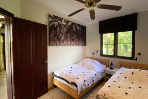 a bedroom with two beds and a ceiling fan at Family-friendly house, a few steps from the pool and close to the ocean. in Mae Pim +37 photos