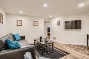 uma sala de estar com um sofá e uma televisão de ecrã plano em Sloans Lake Getaway Near Broncos & Downtown Denver em Lakewood