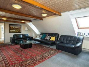 - un salon doté d'un mobilier en cuir noir et d'un tapis rouge dans l'établissement 10 person holiday home in Karby, à Karby