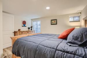 a bedroom with a blue bed and a window at Sloans Lake Getaway - Basement Apartment Near Broncos and Downtown Denver in Lakewood