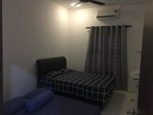 Fadi's Guesthouse at Bandar Baru Samariang في كوتشينغ: غرفه فيها سرير واريكه