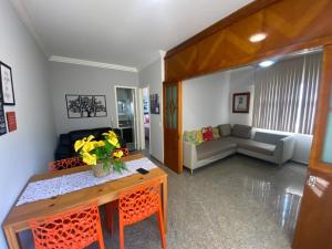 ein Wohnzimmer mit einem Sofa und einem Tisch in der Unterkunft Vem pra cá! Localização Privilegiada! in Guarapari