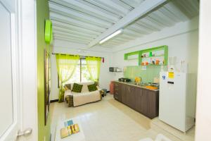 a kitchen with a refrigerator and a couch in a room at Apartamentos Turísticos El Conquistador in San Andrés